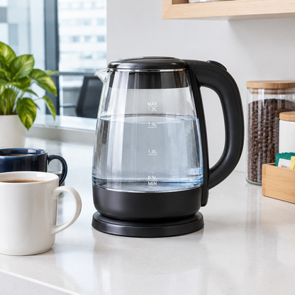 Hervidor eléctrico Frijol negro con cuerpo de cristal en un office de oficina junto a tazas de café