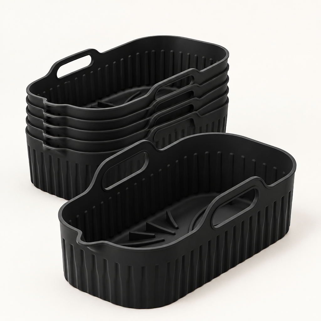 Pack de 6 bandejas rectangulares de silicona negras Manacor para freidora de aire, de 8 por 20 por 12 cm, sobre una superficie clara